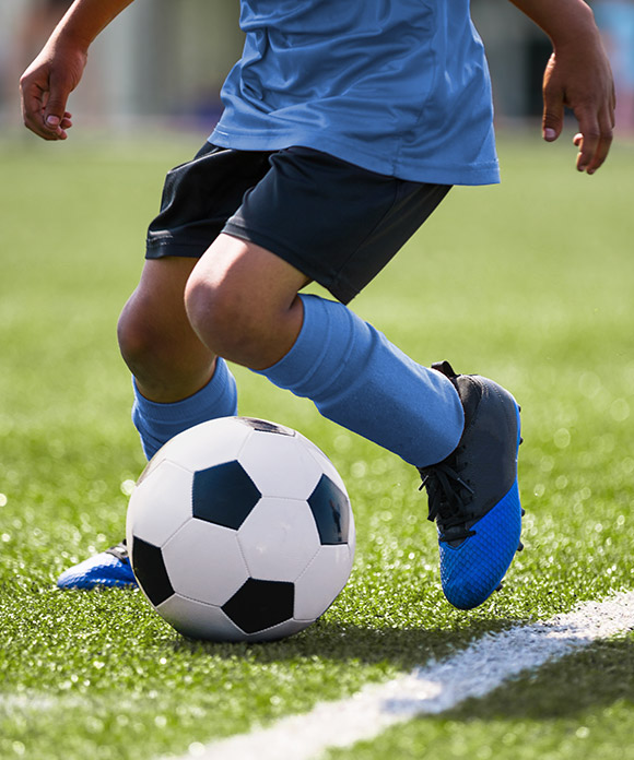 child kicking soccer ball on soccer Brookfield soccer field at a park